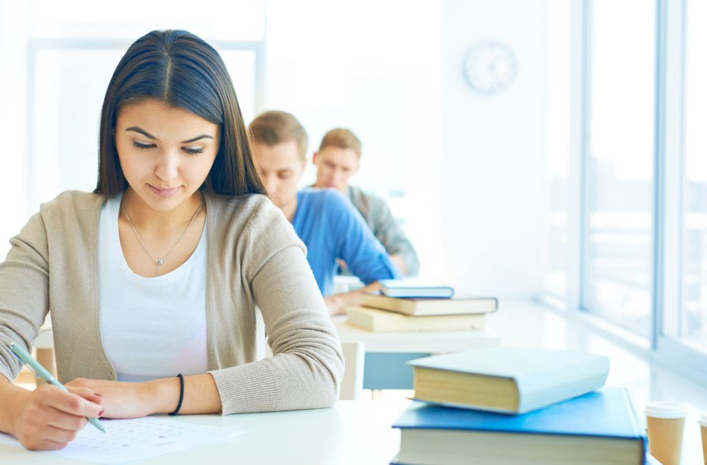 educacao-financeira. Mulher sorrindo e escrevendo